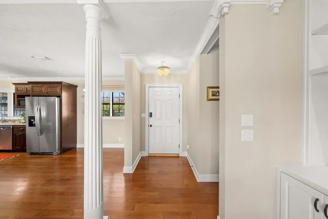 a view of a hallway with wooden floor and a living room