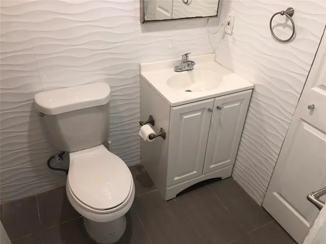 a bathroom with a toilet sink and mirror