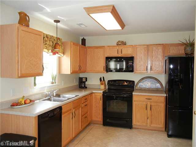 6925 Channel Forest Road Belews Creek, NC 27009 - Photo 4 of 16 Kitchen. Kitchen has a recent appliances that include a smooth top stove, dishwasher, and built-in microwave. Pantry and lazy susan for storage!