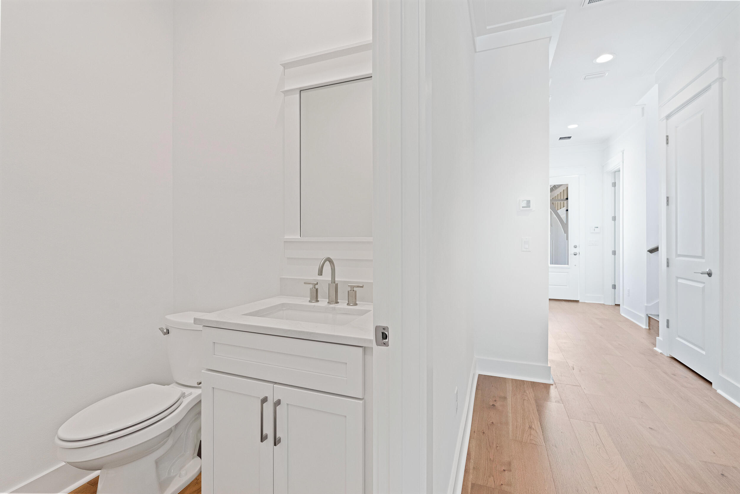 29 Pollard Cove, Unit LOT 3 Watersound, FL 32461 - Photo 19 of 69 a bathroom with a toilet sink vanity and mirror