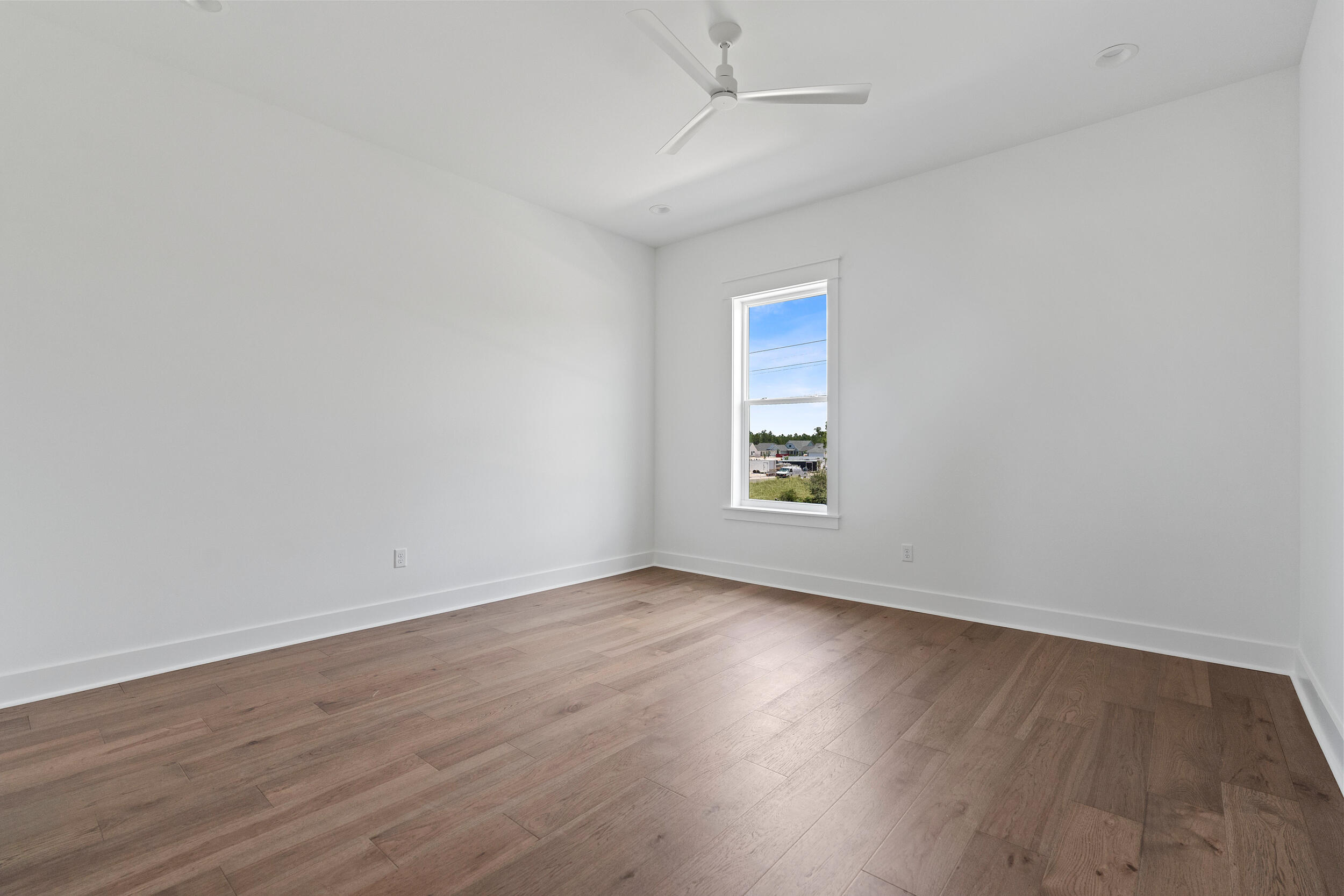29 Pollard Cove, Unit LOT 3 Watersound, FL 32461 - Photo 32 of 69 an empty room with wooden floor chandelier fan and windows