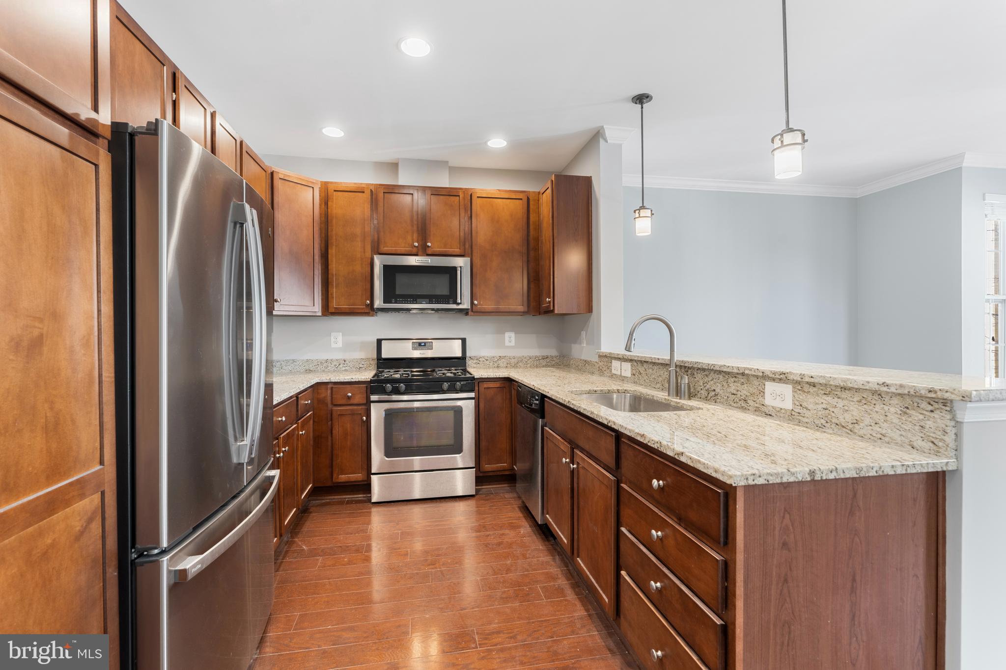 11246 Chase Street, Unit 141 Fulton, MD 20759 - Photo 13 of 37 a kitchen with stainless steel appliances granite countertop a refrigerator a stove a sink and a microwave