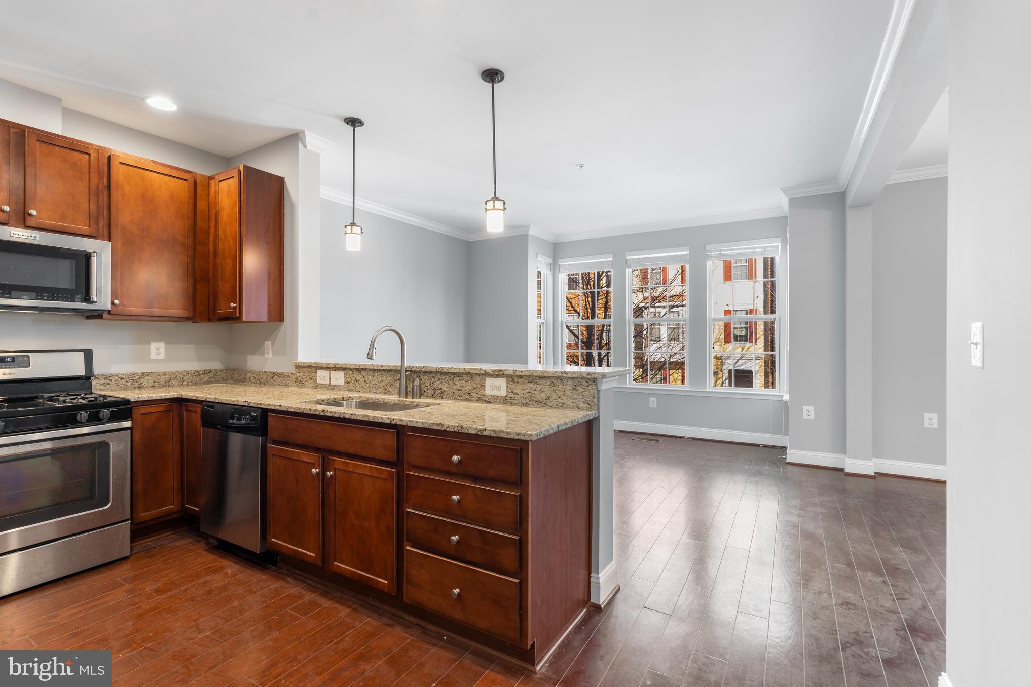11246 Chase Street, Unit 141 Fulton, MD 20759 - Photo 14 of 37 a kitchen with granite countertop a stove a sink and a microwave