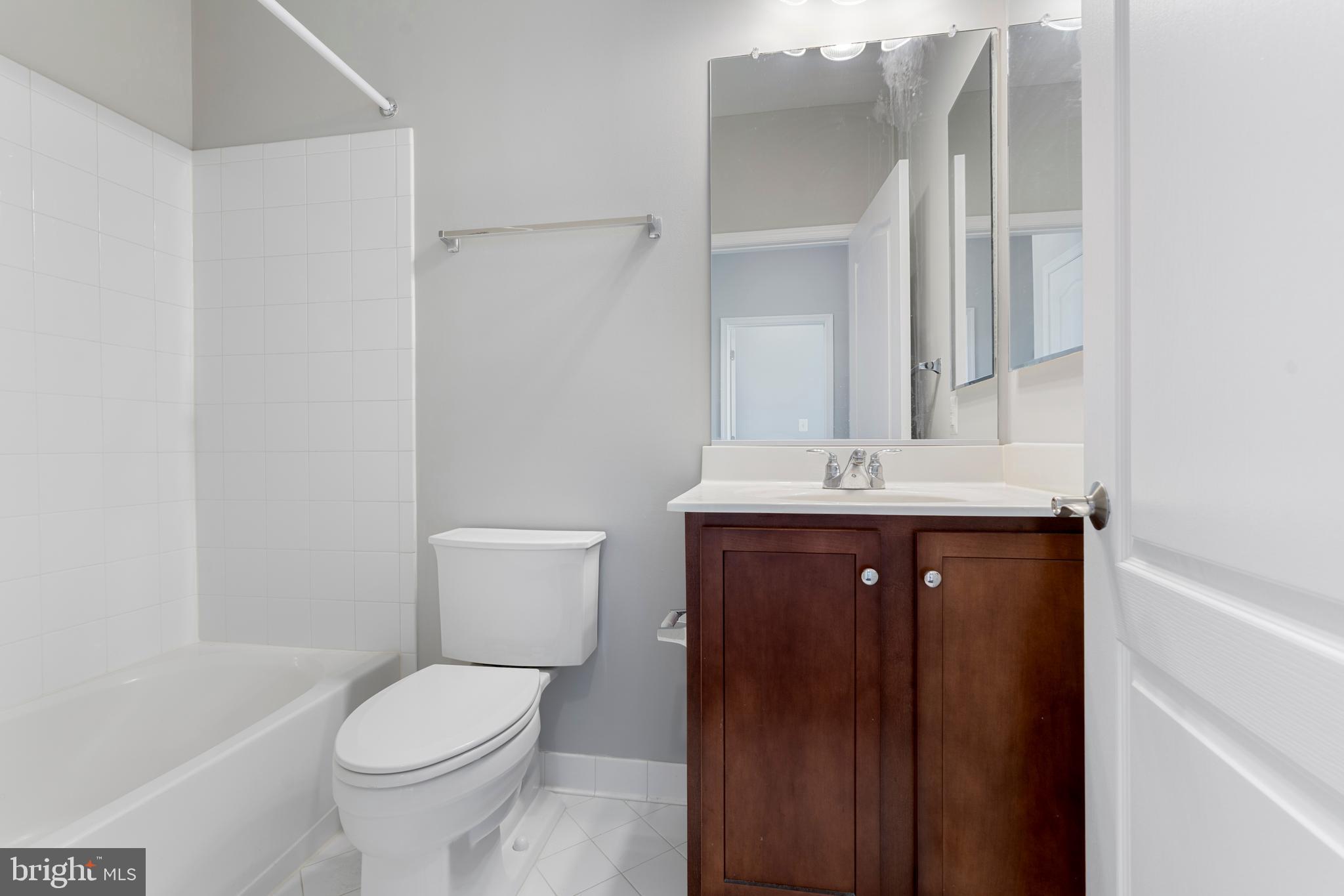 11246 Chase Street, Unit 141 Fulton, MD 20759 - Photo 32 of 37 a bathroom with a sink vanity mirror and toilet