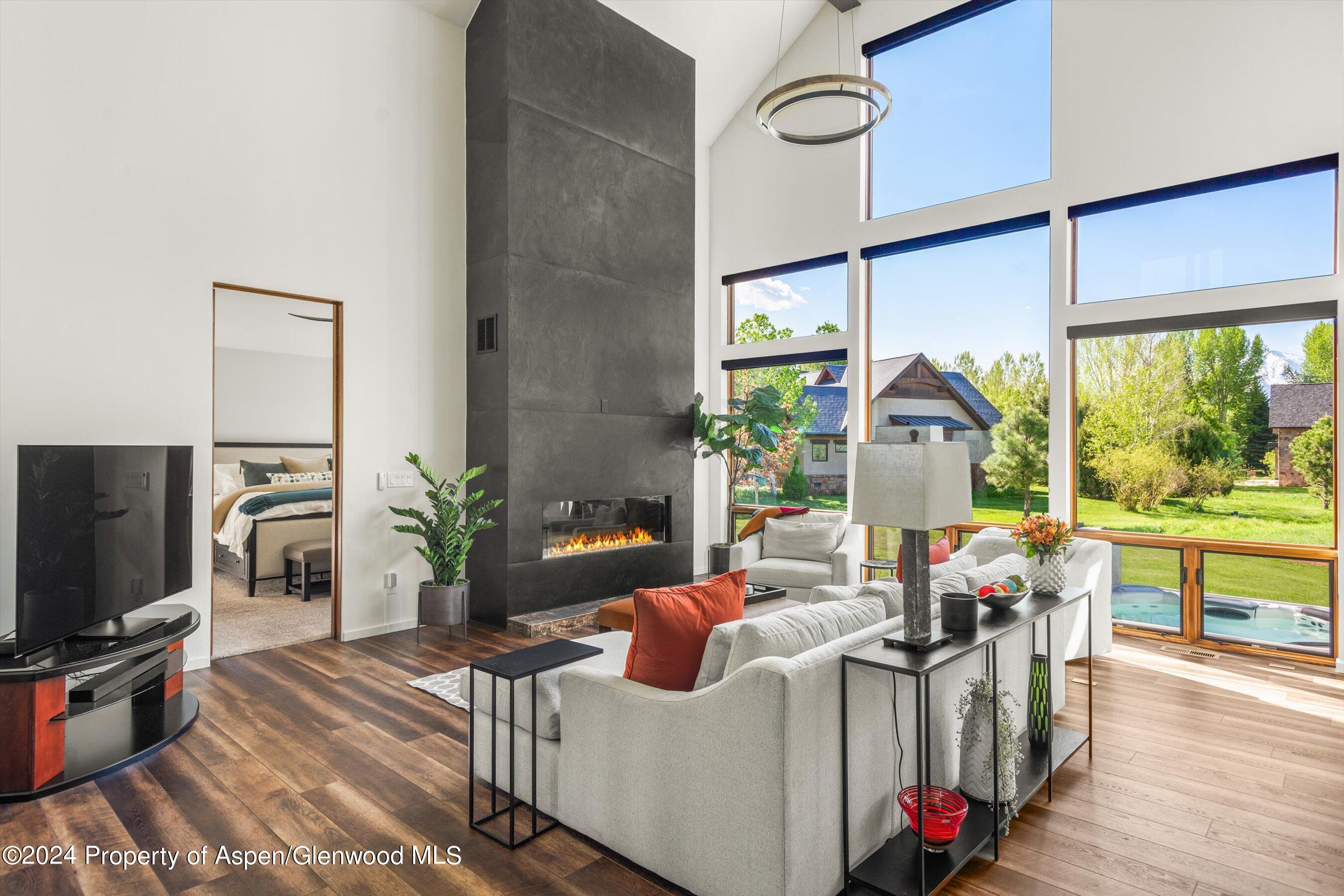 16 Puma Carbondale, CO 81623 - Photo 6 of 21 a living room with furniture a flat screen tv and a floor to ceiling window