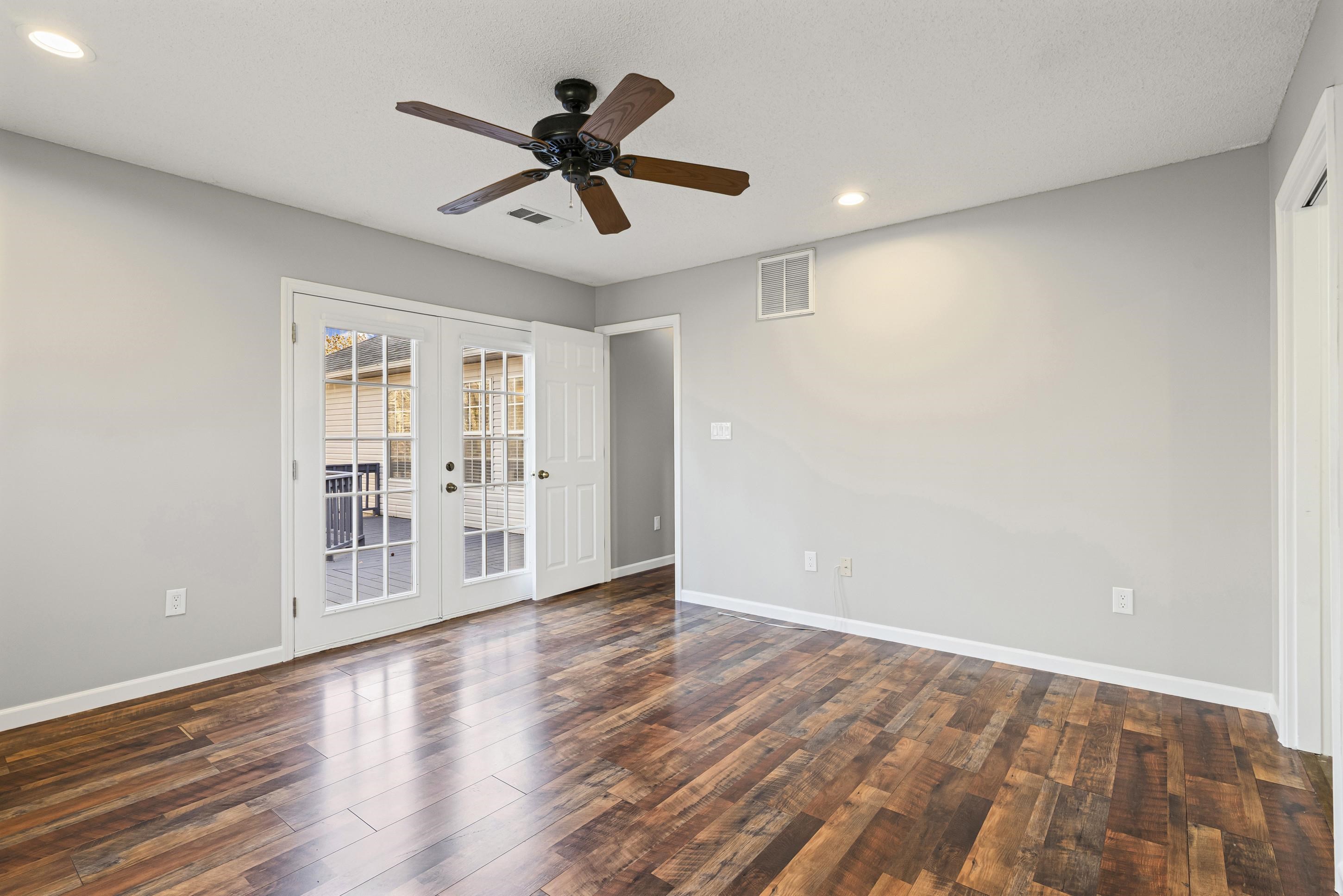 225 Poplar Grove Church Road Drummonds, TN 38023 - Photo 13 of 30 a view of an empty room with wooden floor and a ceiling fan