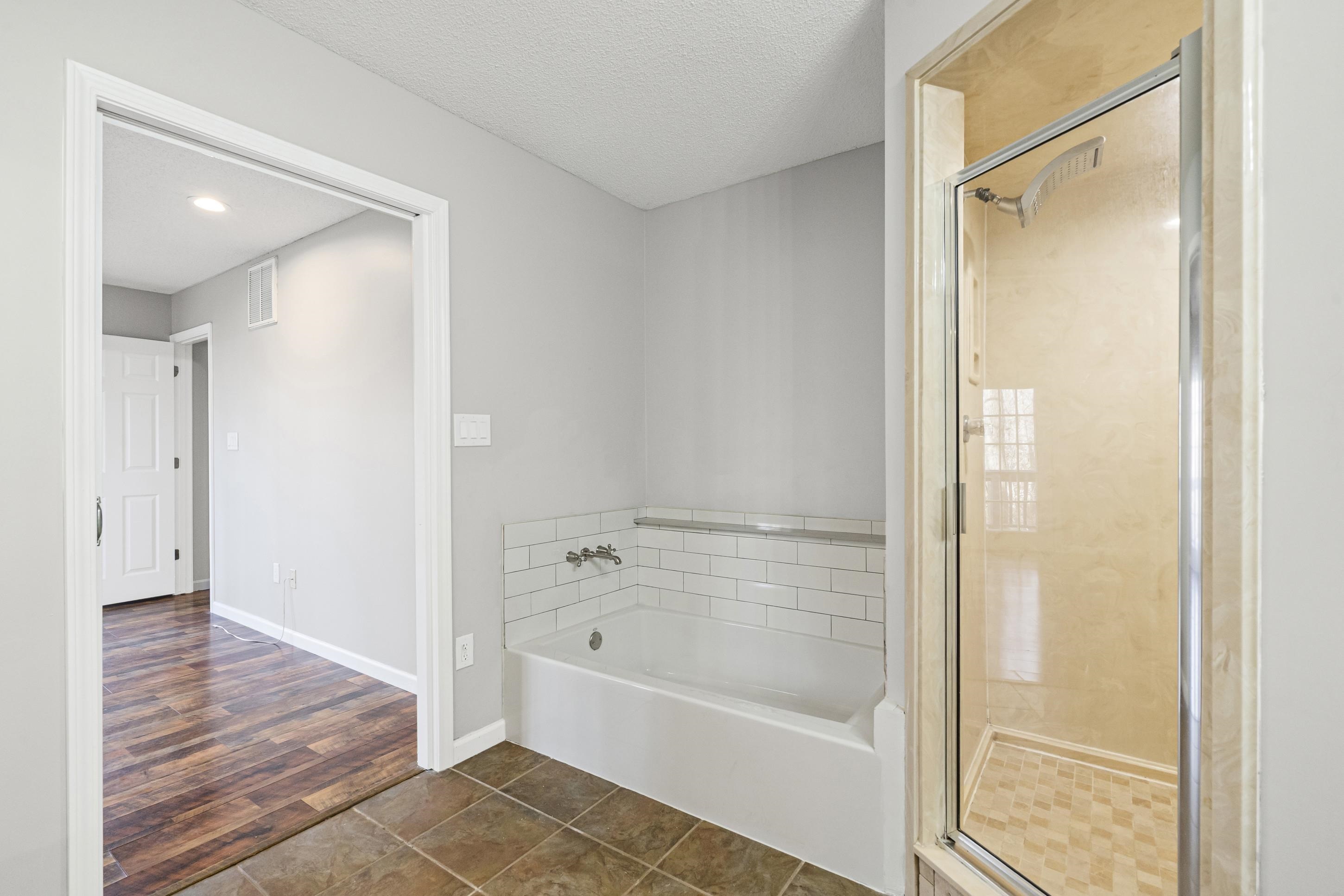 225 Poplar Grove Church Road Drummonds, TN 38023 - Photo 15 of 30 a bathroom with a bathtub and a shower