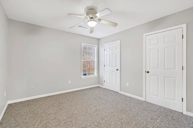 a view of an empty room with a ceiling fan