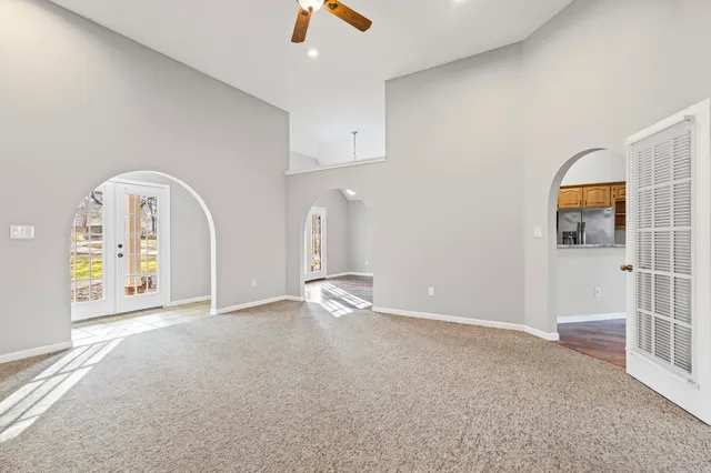 an empty room with ceiling fan and window
