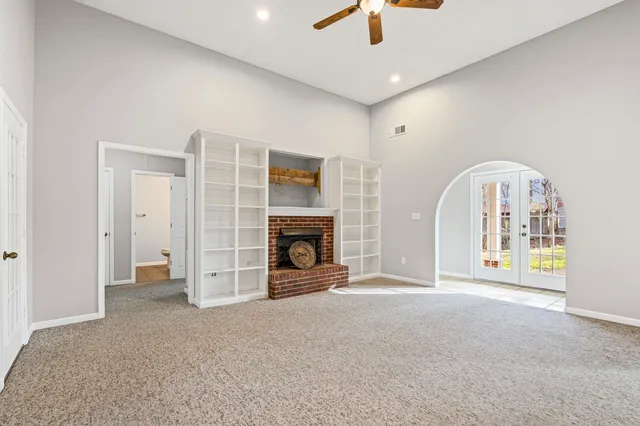 an empty room with fireplace and windows