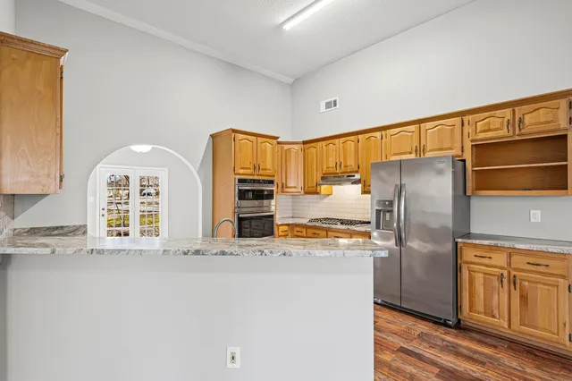 a large kitchen with stainless steel appliances a refrigerator and a stove top oven