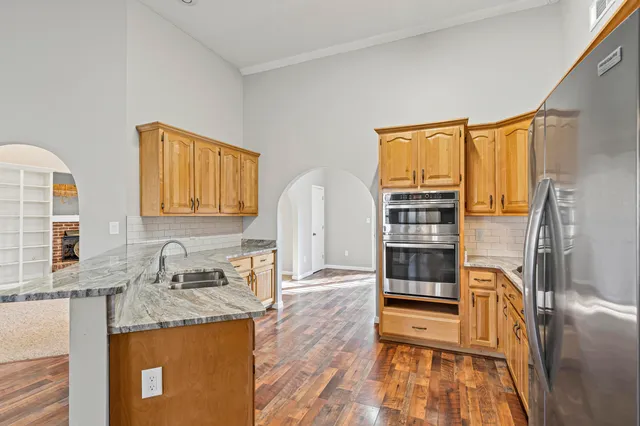 a kitchen with stainless steel appliances granite countertop a stove a sink and a refrigerator
