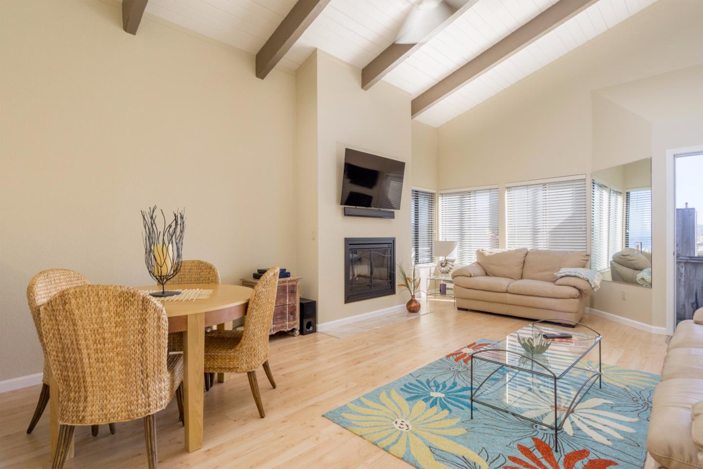 1 Surf Way, Unit 228 Monterey, CA 93940 - Photo 3 of 13 a living room with furniture a flat screen tv and a fireplace