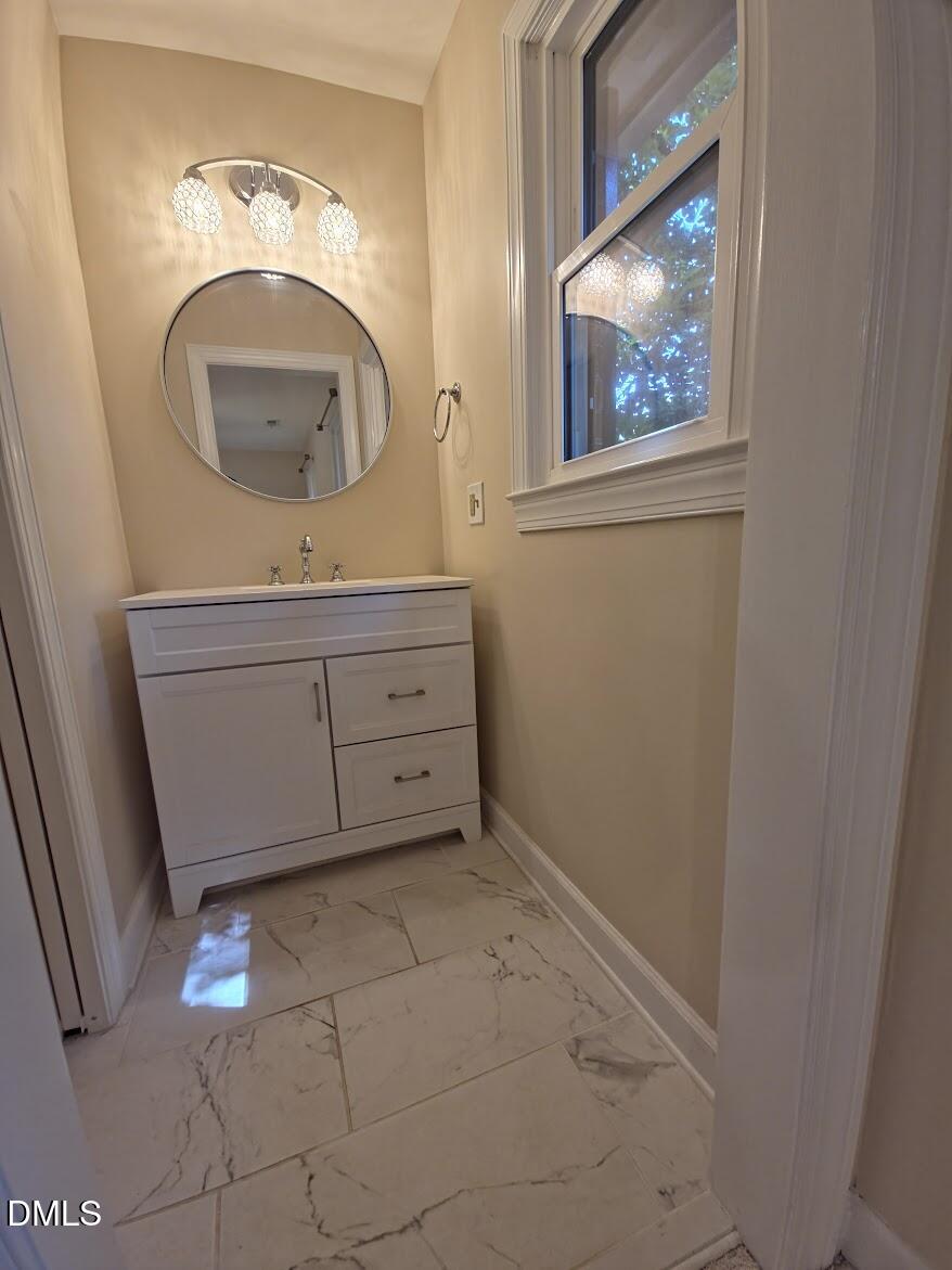 6844 Gloucester Road Raleigh, NC 27612 - Photo 12 of 25 a bathroom with a sink a mirror and vanity
