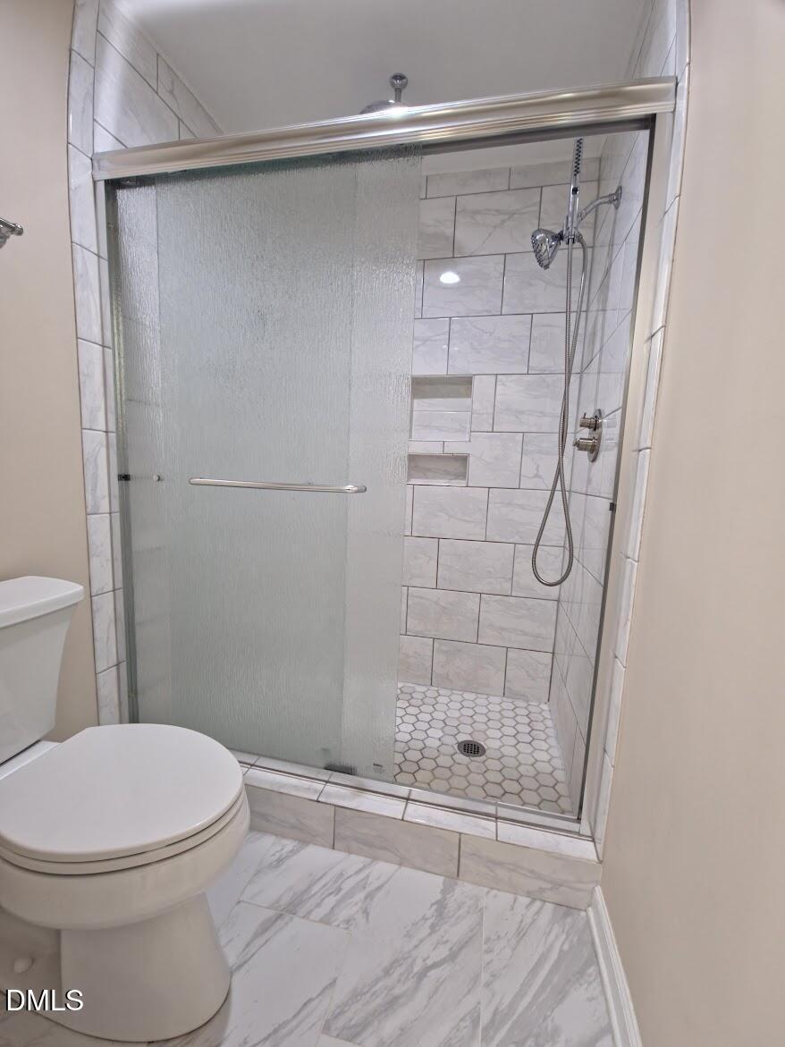 6844 Gloucester Road Raleigh, NC 27612 - Photo 15 of 25 a bathroom with a shower and a toilet