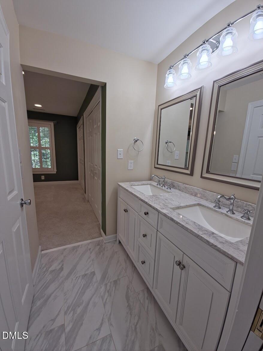 6844 Gloucester Road Raleigh, NC 27612 - Photo 16 of 25 a spacious bathroom with a double vanity sink and a mirror
