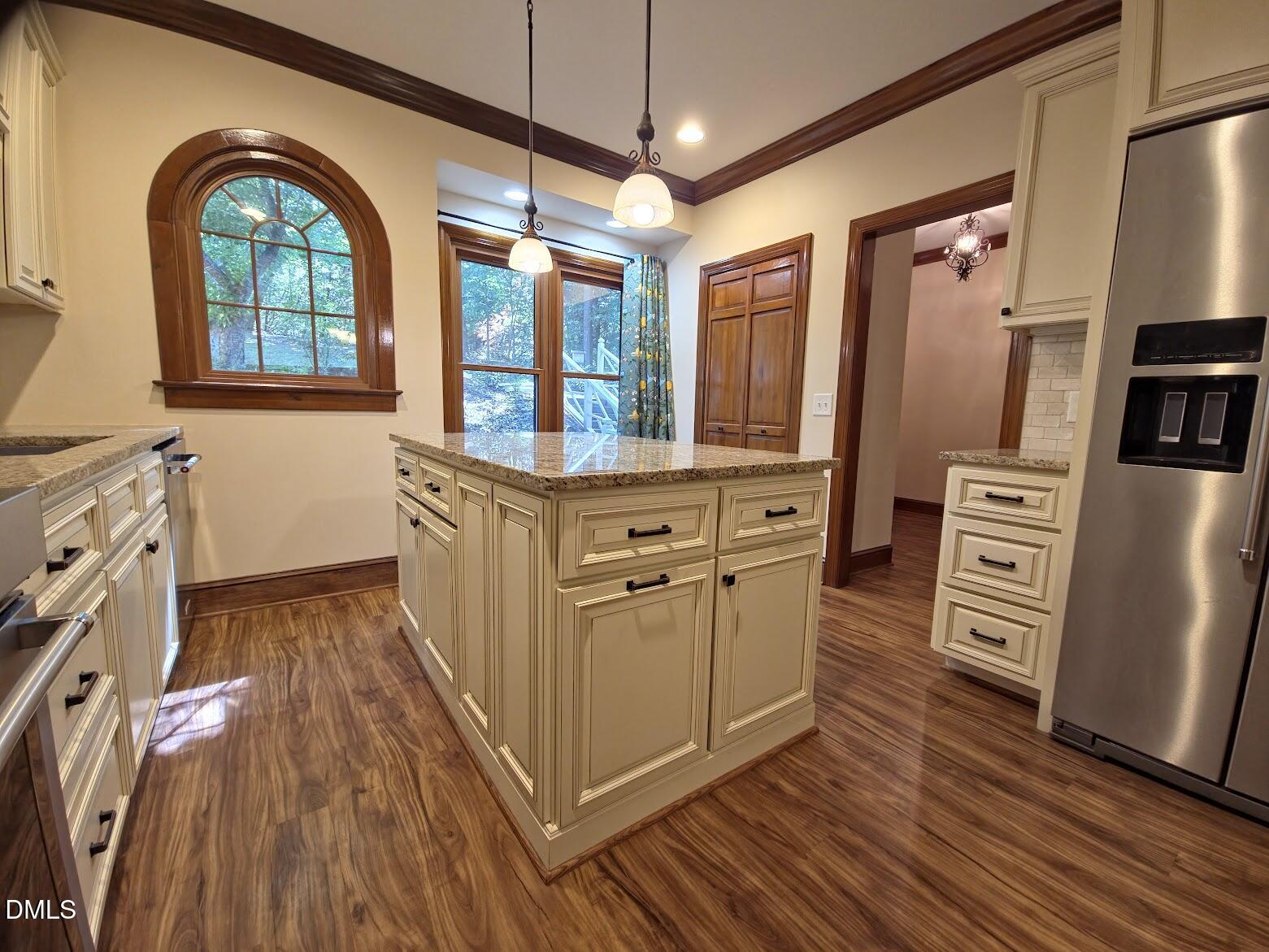 6844 Gloucester Road Raleigh, NC 27612 - Photo 2 of 25 a kitchen with stainless steel appliances a stove a refrigerator a sink with wooden floor and cabinets