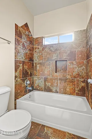 an empty room with a chandelier fan and windows