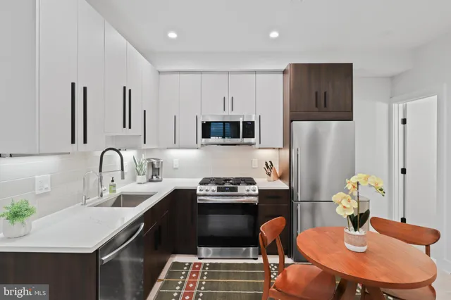 a kitchen with stainless steel appliances kitchen island granite countertop a stove and a sink