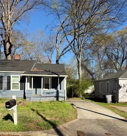 a front view of a house with garden and trees