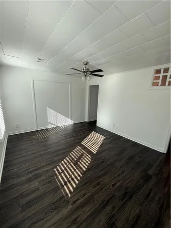 a view of an empty room with wooden floor
