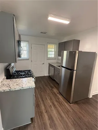 a kitchen with granite countertop a refrigerator and a stove