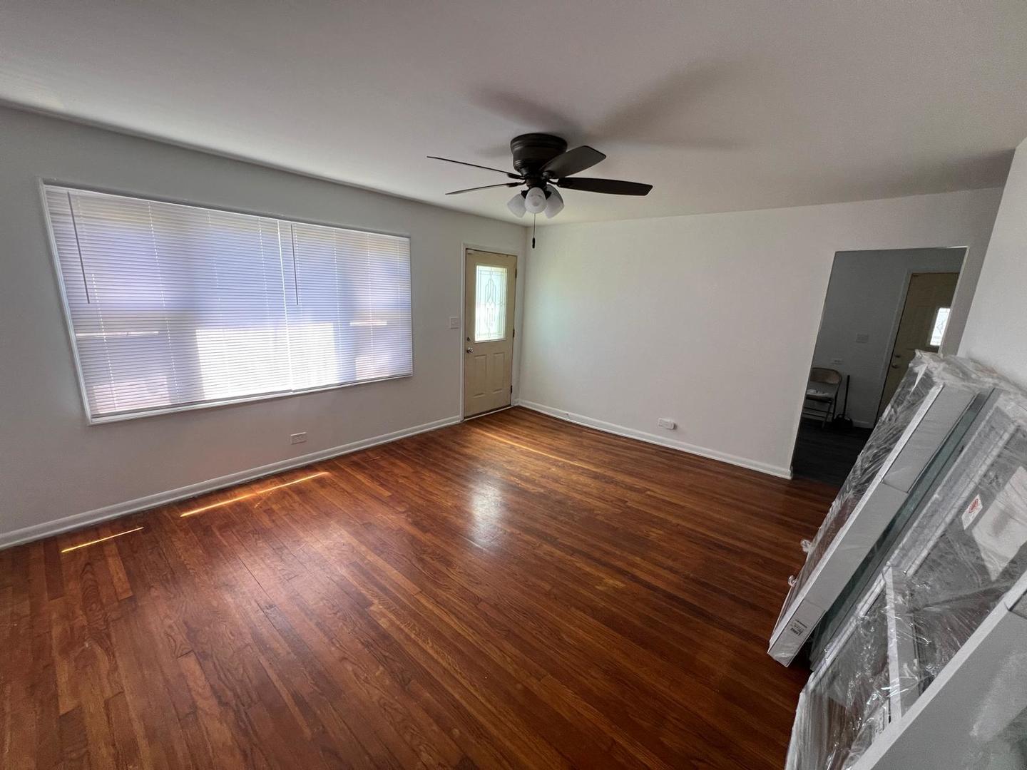 16442 Honore Avenue Markham, IL 60428 - Photo 12 of 16 a view of an empty room with wooden floor and a window