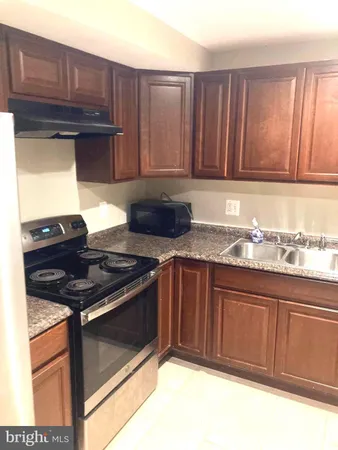 a kitchen with granite countertop stainless steel appliances stove and cabinets