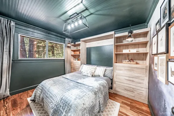 a bedroom with a large bed and a flat tv screen