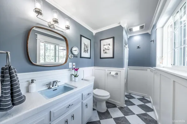 a bathroom with a sink a toilet and a mirror