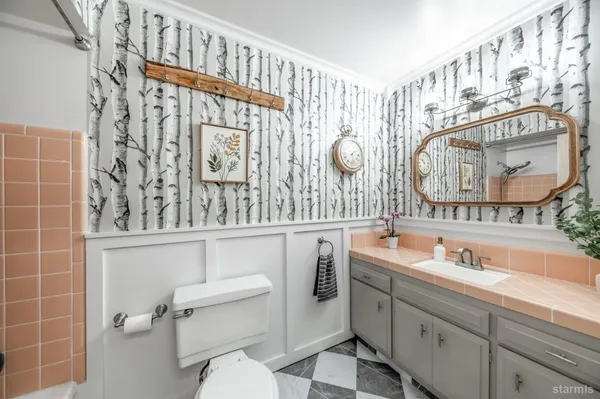 a bathroom with a sink mirror vanity and toilet