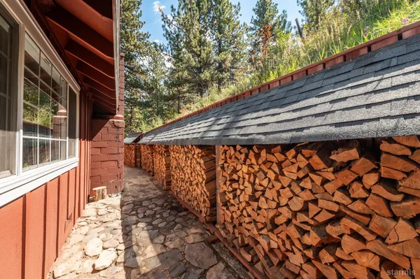 a backyard of a house with wooden fence and large trees