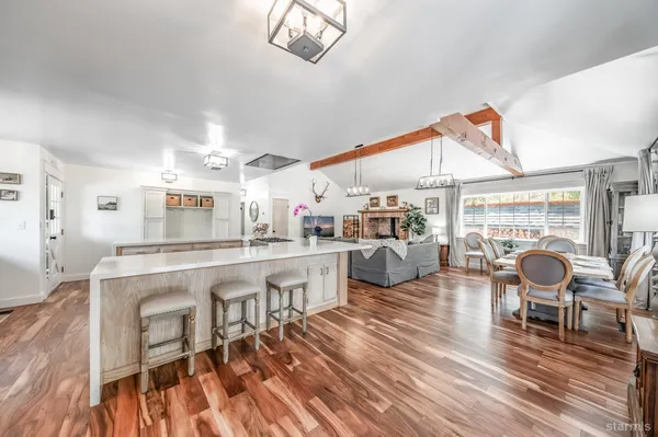 a living room with furniture a rug and kitchen view