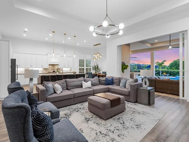 a kitchen with stainless steel appliances granite countertop a table chairs sink refrigerator and cabinets