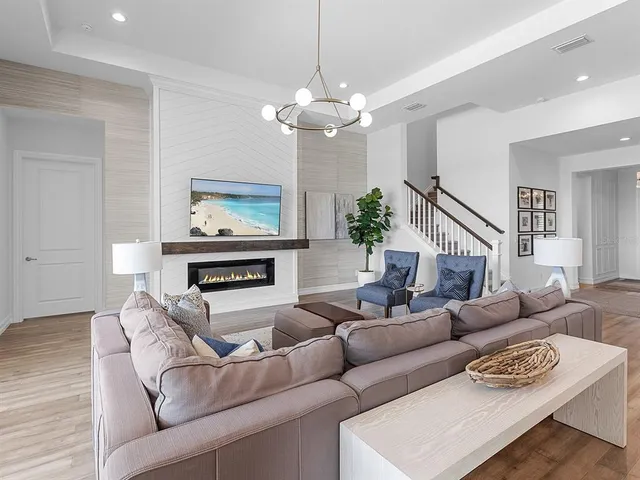 a living room with furniture a flat screen tv and a fireplace