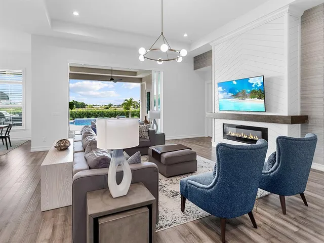 a living room with furniture a chandelier and a fireplace