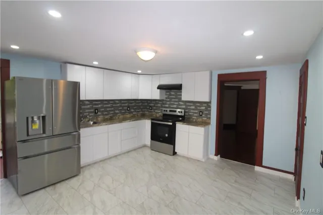 a kitchen with stainless steel appliances a refrigerator and a stove top oven