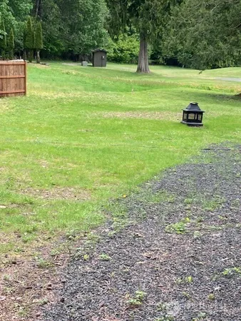 a view of a golf ground with huge green field and trees