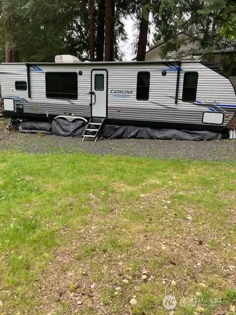 a view of a white house with a big yard and sitting area