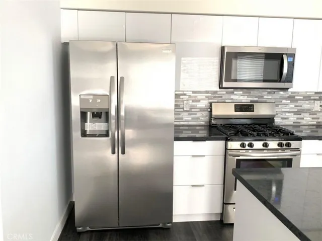 a kitchen with a refrigerator microwave and stove