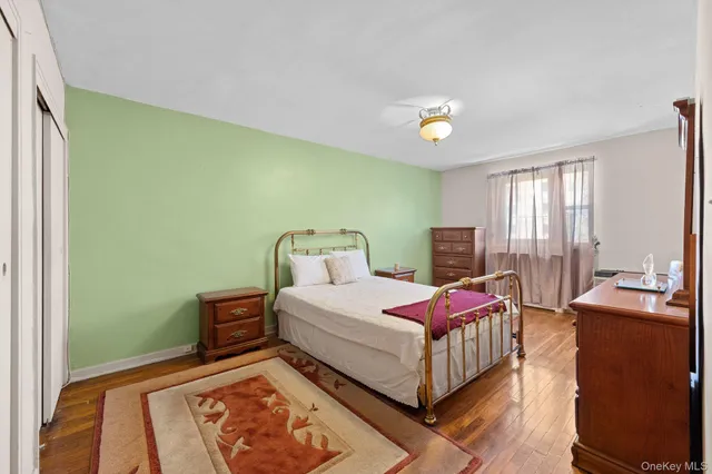 a spacious bedroom with a bed and wooden floor