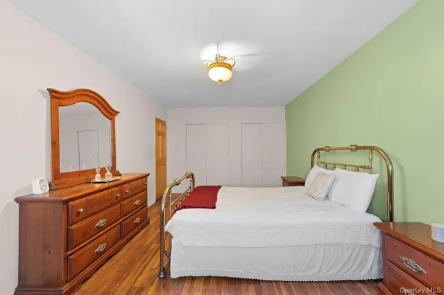 a bedroom with a bed and a dresser with mirror