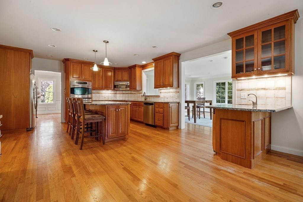 31 Fuller Road Needham, MA 02492 - Photo 12 of 42 a kitchen with stainless steel appliances granite countertop wooden floors and white cabinets