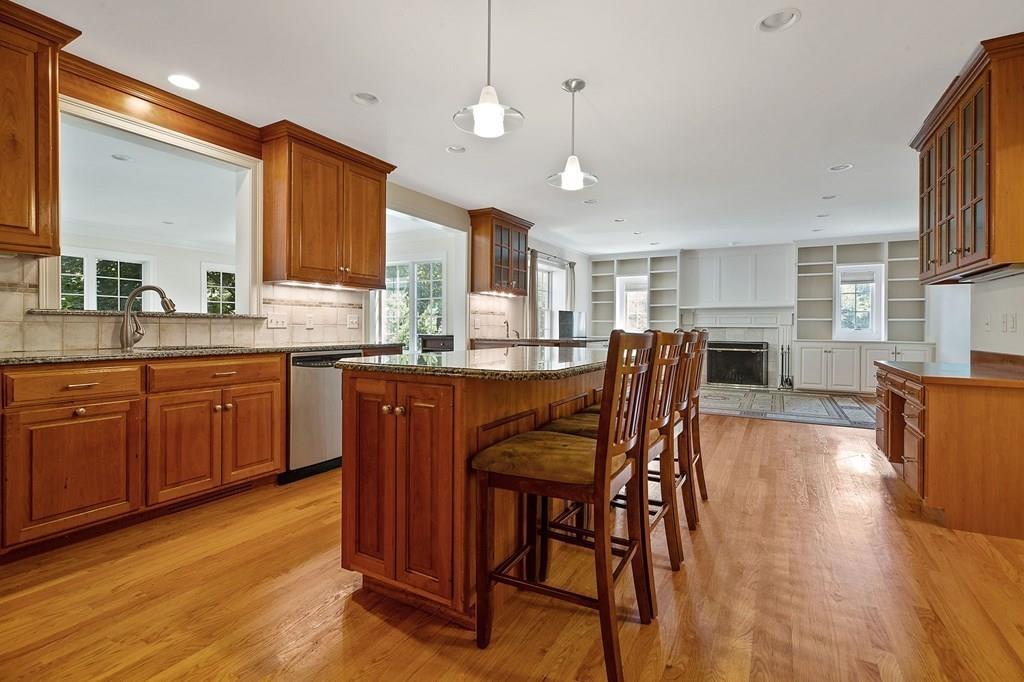 31 Fuller Road Needham, MA 02492 - Photo 9 of 42 a kitchen with stainless steel appliances granite countertop wooden cabinets a dining table and chairs
