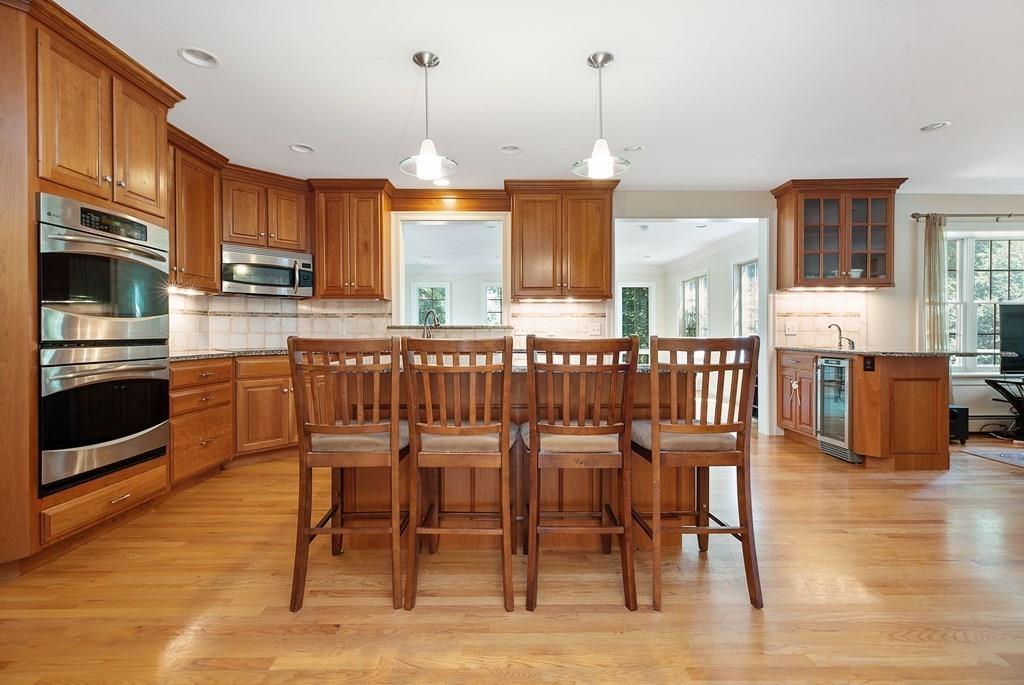 31 Fuller Road Needham, MA 02492 - Photo 10 of 42 a kitchen with stainless steel appliances granite countertop a stove top oven a sink a dining table and chairs with wooden floor