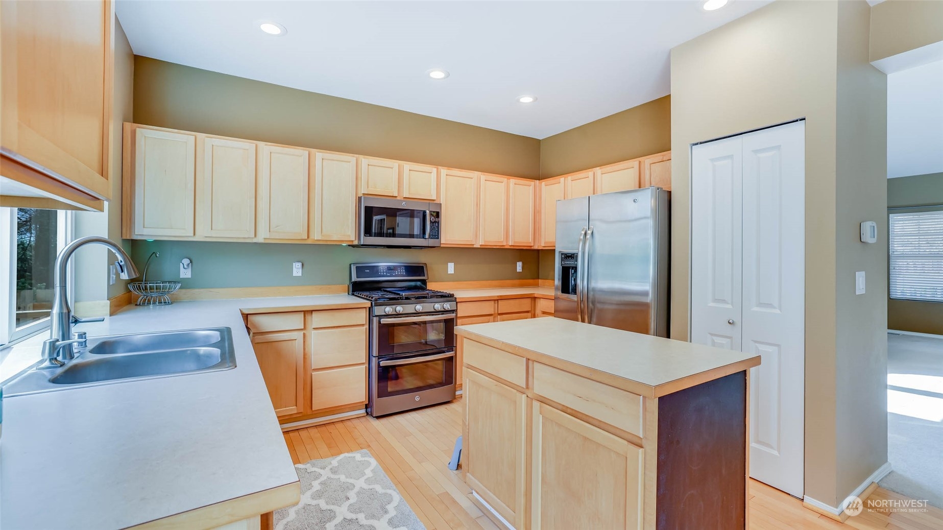 28120 Maple Ridge Way Southeast Maple Valley, WA 98038 - Photo 10 of 36 a kitchen with stainless steel appliances a sink a stove a microwave a sink a refrigerator and cabinets