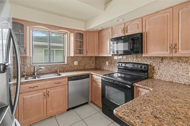 a kitchen with cabinets appliances a sink and a window