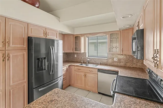 a kitchen with stainless steel appliances granite countertop a refrigerator and a sink