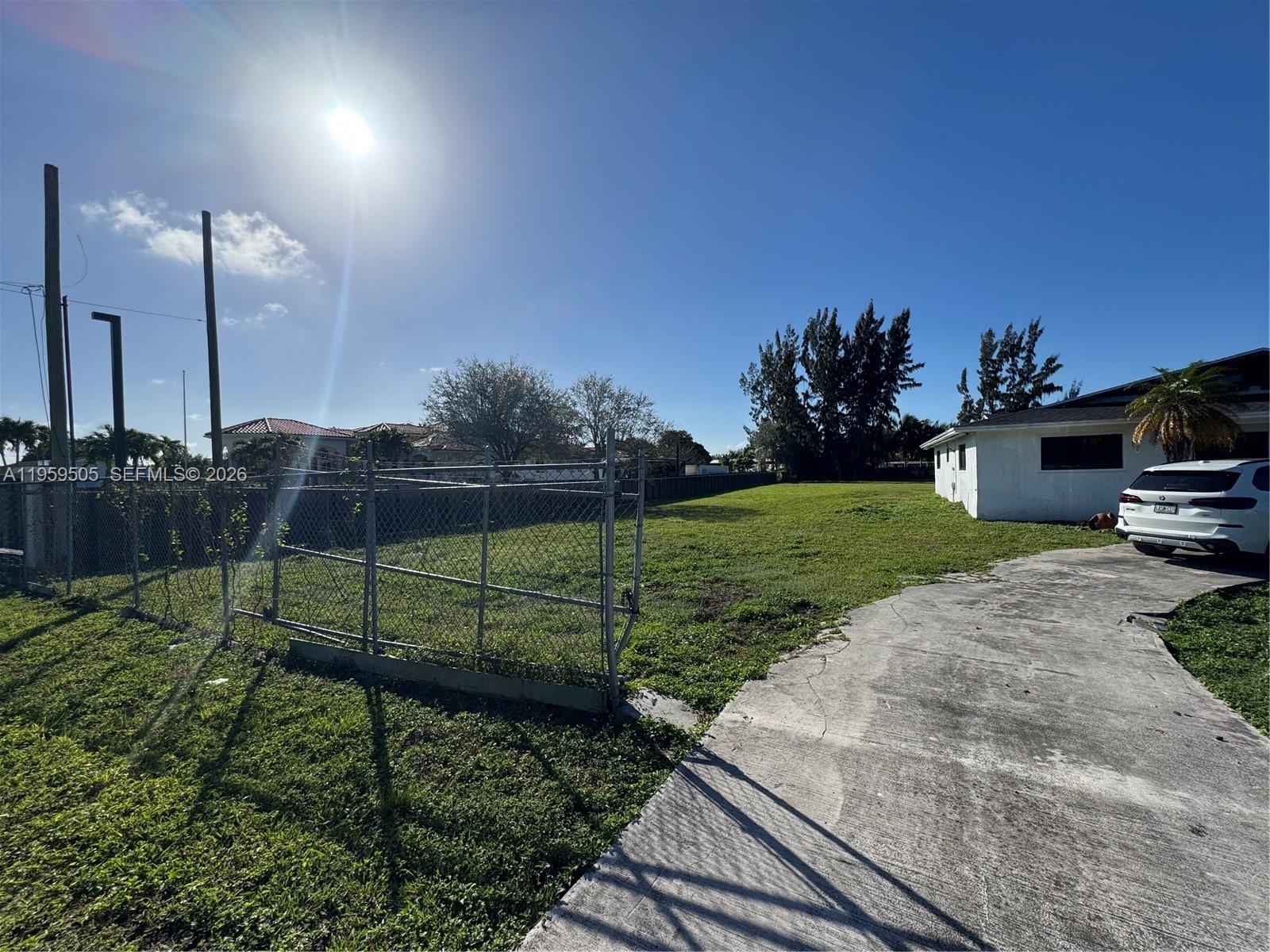19530 Southwest 210th Street Miami, FL 33187 - Photo 6 of 20 a view of a backyard with grass & fence