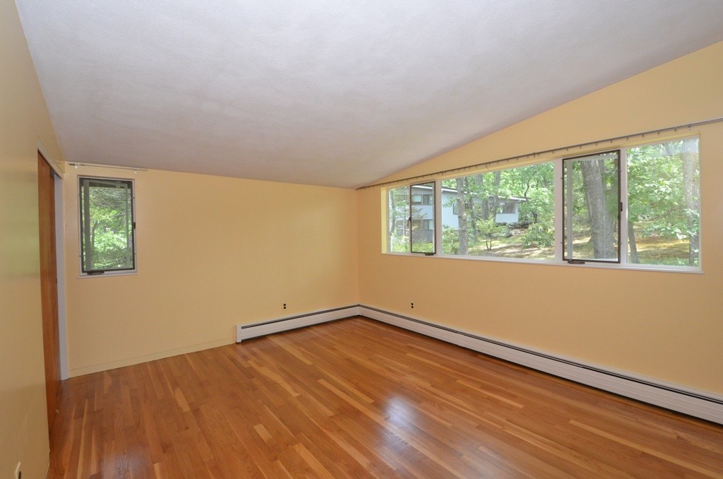 39 Peacock Farm Road Lexington, MA 02421 - Photo 13 of 30 an empty room with wooden floor and windows